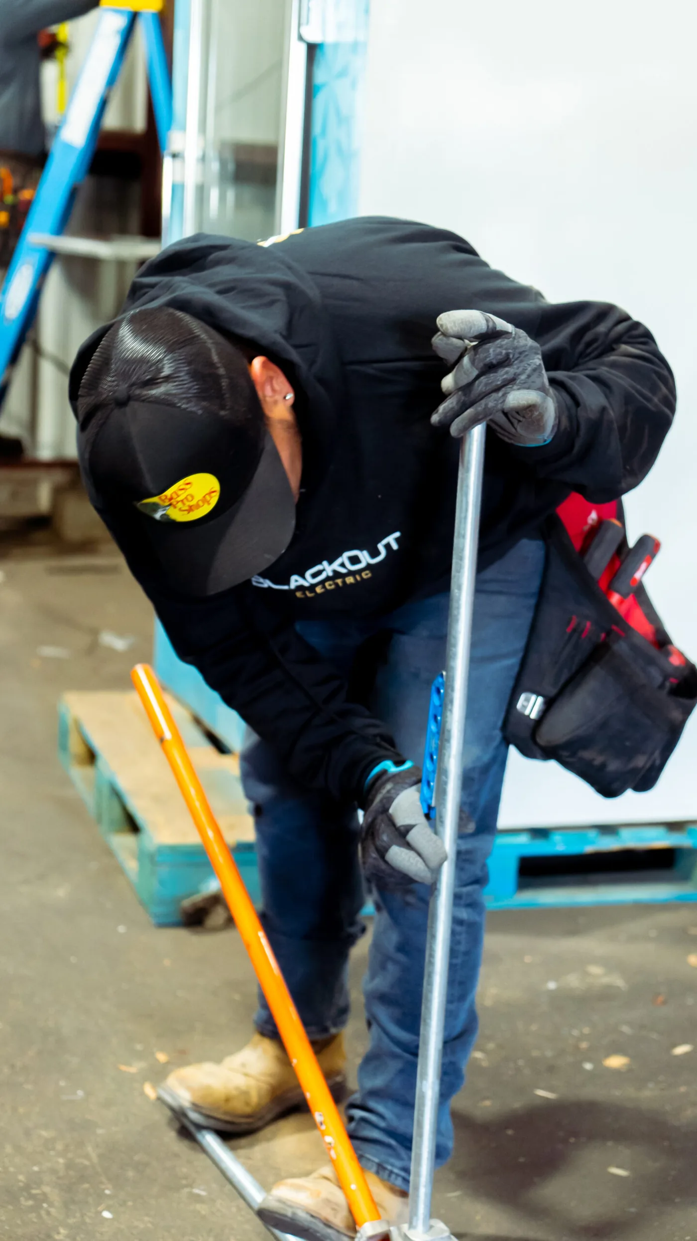 Tech working an EMT conduit bend with a level clamped to the pipe